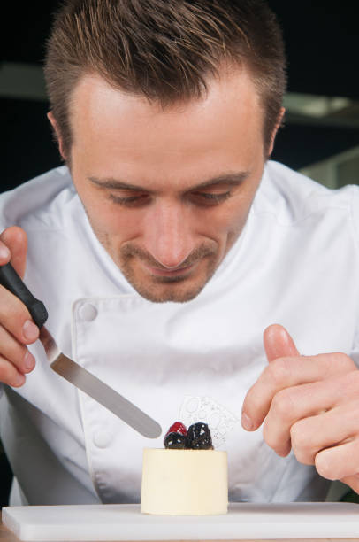 istock Smiling chef decorating ice-cream with berries 1152753364