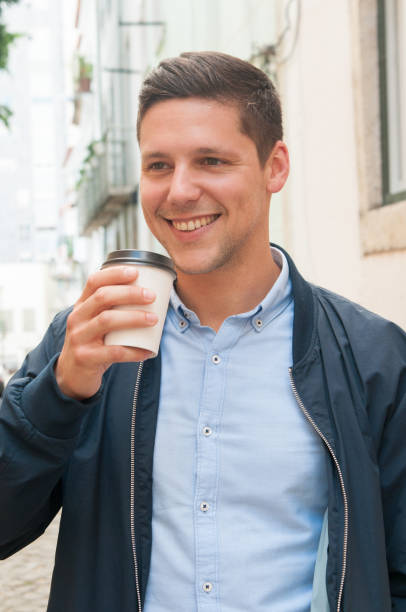 istock Happy positive student drinking takeaway coffee 1152753912