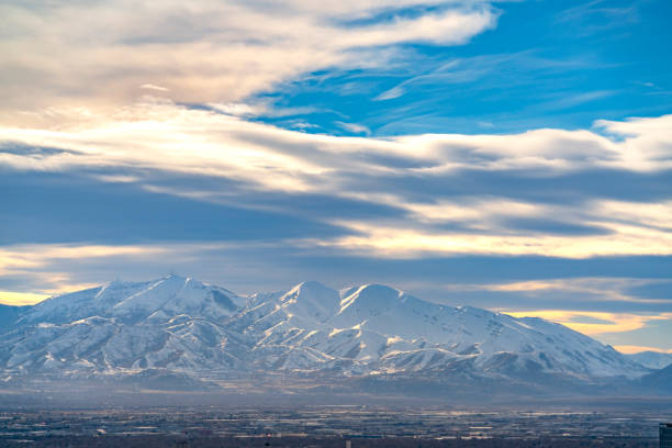 istock Striking sunlit mountain coated with snow under a vivid blue sky with clouds 1152757121