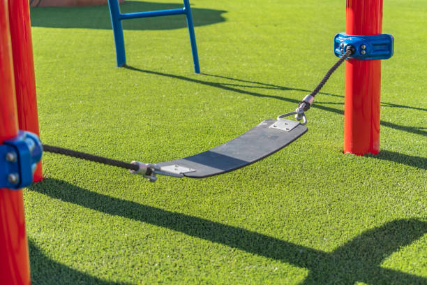 istock Play area with a seat supported by ropes that are connected to red poles 1152757182