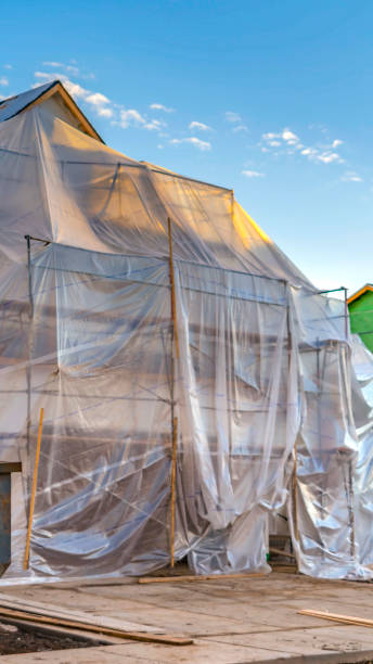 istock Vertical frame Plastic sheet covering an unfinished house and scaffoldings against blue sky 1152757242