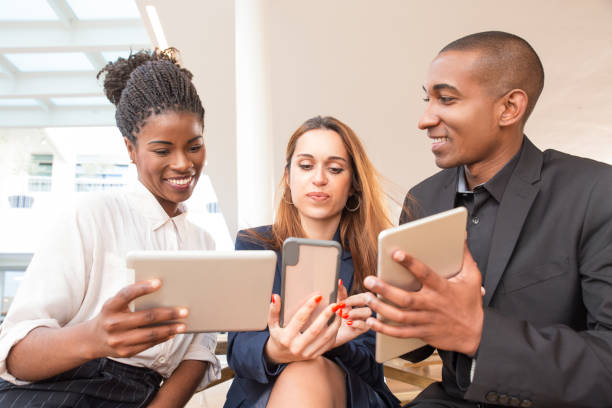 istock Three happy businesspeople using gadgets in office 1152757560