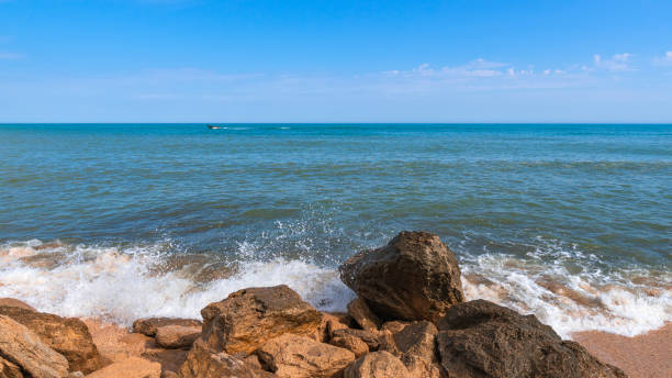 istock Summer beach with rocks and splashing waves 1152760874