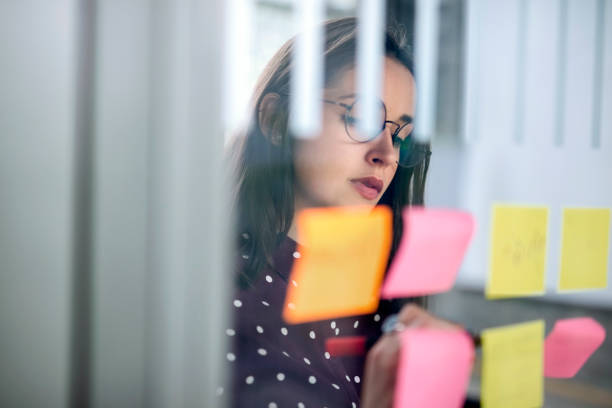 istock Woman writing on sticky note in brainstorming meeting 1152762554
