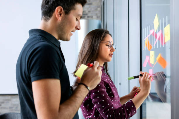 istock Business partners discussing ideas with sticky notes 1152763194