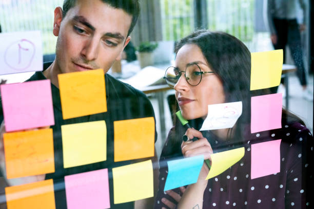 istock Two business people discussing ideas on sticky notes 1152763793
