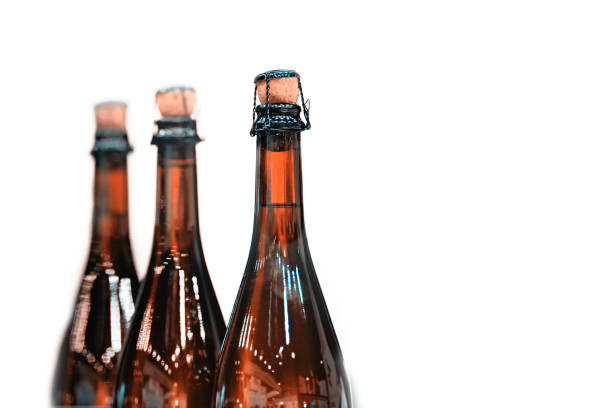 Several glass bottles of champagne with stoppers. Tube holding the wire. The background is blurred.
