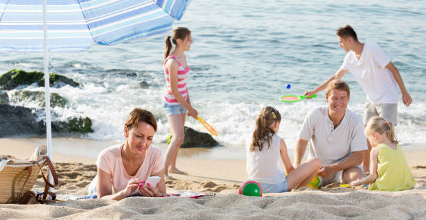 istock family with four kids relaxing on beach 1152766501