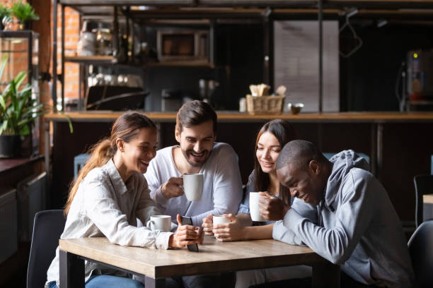 istock Diverse friends having fun in cafe, looking at smartphone screen 1152767818