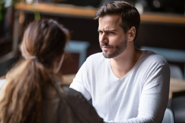 dudar hombre insatisfecho mirando a la mujer, mal concepto de primera cita - hombre sospechoso fotografías e imágenes de stock