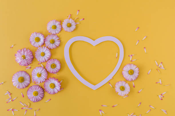 istock Greeting card with heart and daisies on an orange background. 1152768021