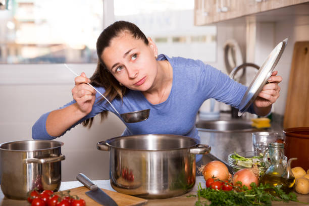 istock Young woman cooks soup in the kitchen 1152772645
