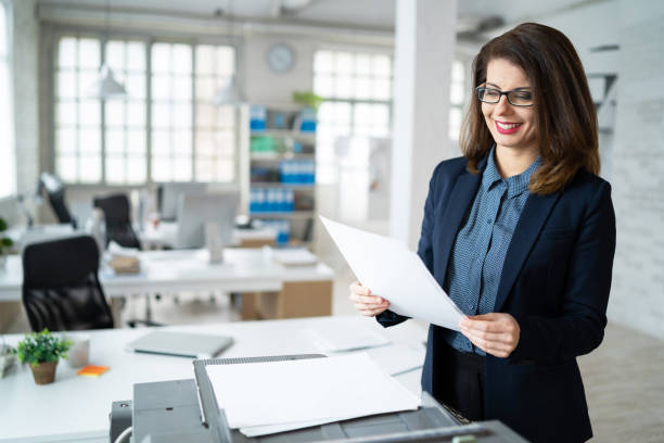 jeune femme d’affaires imprime sur l’imprimeur dans le bureau - fax paper photos et images de collection