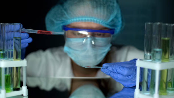 laboratory worker studying blood sample on test glass, medical research, health - human heart flash imagens e fotografias de stock