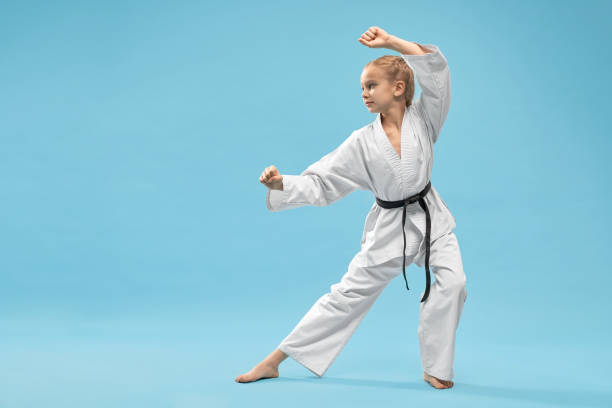 istock Confident girl with black belt standing in stance in studio. 1152779009