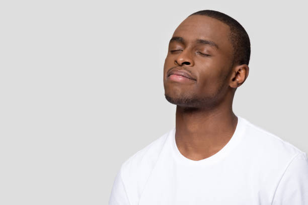 African male closed eyes pose isolated on grey blank