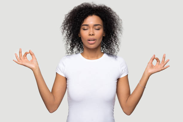 istock African female closed eyes doing yoga over grey background 1152782404