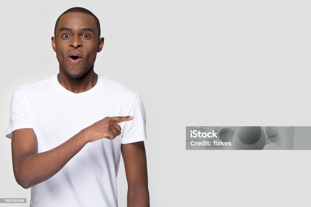 Surprised Funny African Man Pointing Aside Looking At Camera Stock Photo -  Download Image Now - iStock