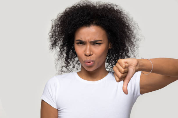 Unsatisfied african woman showing thumb down disapproval gesture