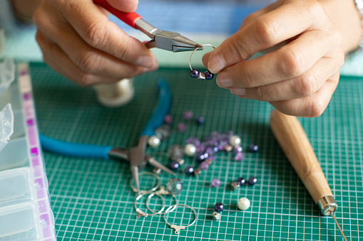 Close Up Of Senior Woman Making Jewellery Earrings At Home