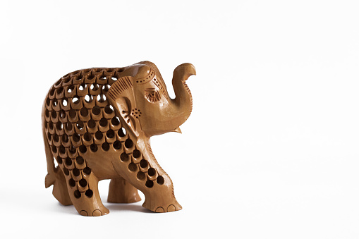 ELEPHANT FIGURE CARVED OUT OF WOOD, CLOSEUP ON WHITE BACKGROUND