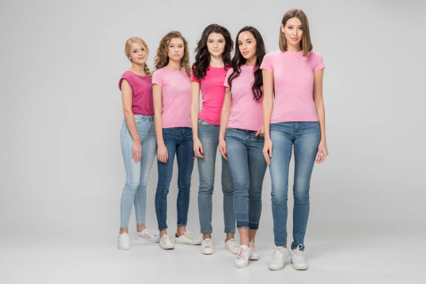 istock beautiful young women standing together on grey background 1152790359