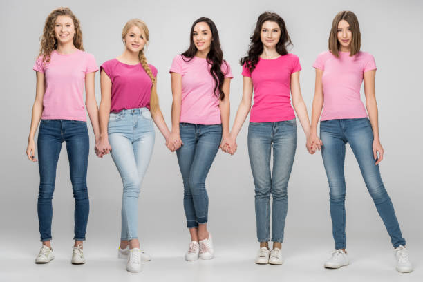 istock cheerful girls holding hands and standing on grey background 1152792051