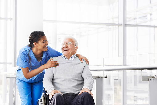 Shot of a young nurse caring for an elderly patient in a wheelchair