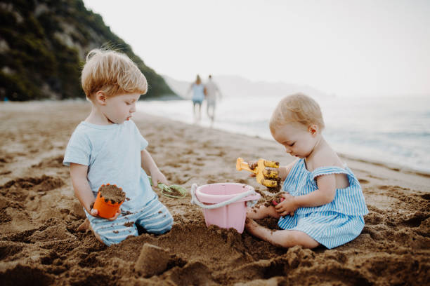 istock Two toddler children playing on sand beach on summer holiday. 1152796558