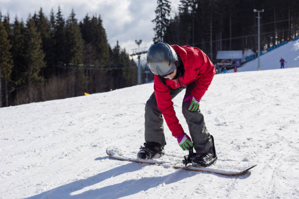 istock Woman fixes snowboard mounts to feet. 1152797082