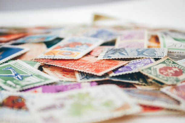 istock Closeup view on a variety of multi-colored postage stamps from different countries and years. Selective focus 1152797458
