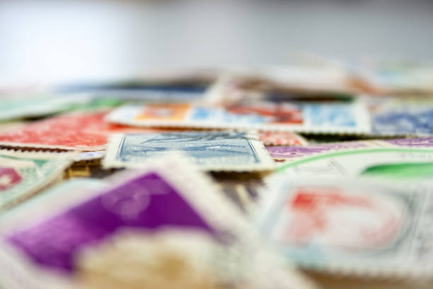 istock Closeup view on a variety of multi-colored postage stamps from different countries and years. Selective focus 1152797484