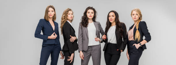 istock beautiful successful women standing with hands in pockets isolated on grey 1152797879