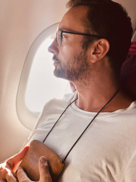 istock Airplane passenger with a neck bag for safe carrying money and documents. 1152798047