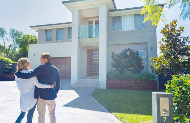 Couple standing in front of their new home.