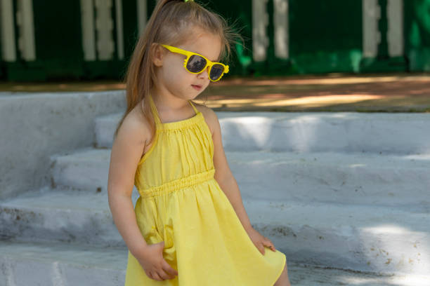 istock Kid dressed a yellow dress and sunglasses 1152810221
