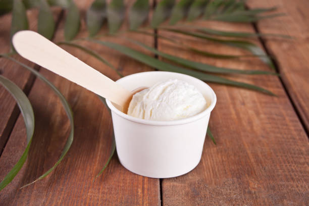 istock Vanilla ice cream with spoon and palm leaf on the wooden background 1152810621