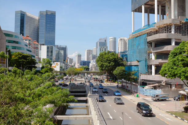 Aerial view onto main road in Singapore Outram. with many lanes. Traffic is ruling on both sites: Eu Tong Sen Street and Ne Bridge Road.. Alomg road are office buildings and at right side is construction site of new building.