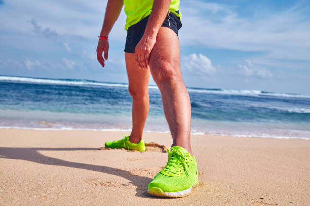 istock Sportsman stretching on a tropical sandy beach. 1152811597