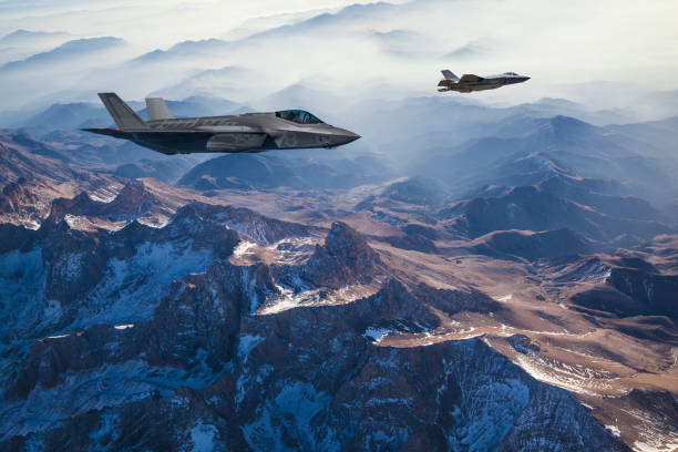 aviones de combate volando sobre las montañas al atardecer - defense industry fotografías e imágenes de stock