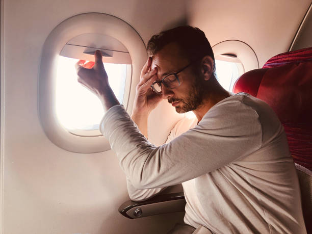 istock Tired / sick passenger in a modern airplane seat next to the window. 1152812180