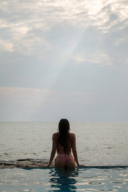 istock Beautiful woman relaxing in the pool with infinity edge 1152814129