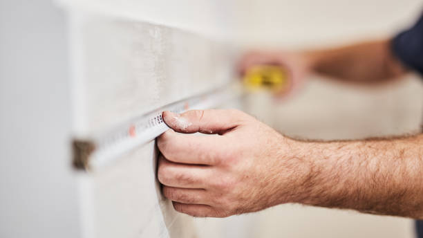 Worksman using tape measure for home renovation. Worksman using tape measure for home renovation. measuring a room stock pictures, royalty-free photos & images