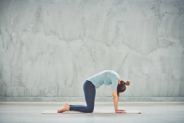 istock Woman doing Cat yoga pose. 1152815749
