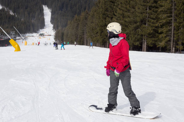 Woman snowboarder on the ski slope. Woman riding down the snowboard on the ski slope. Rest in the ski resort. bukovel ski resort ukraine stock pictures, royalty-free photos & images