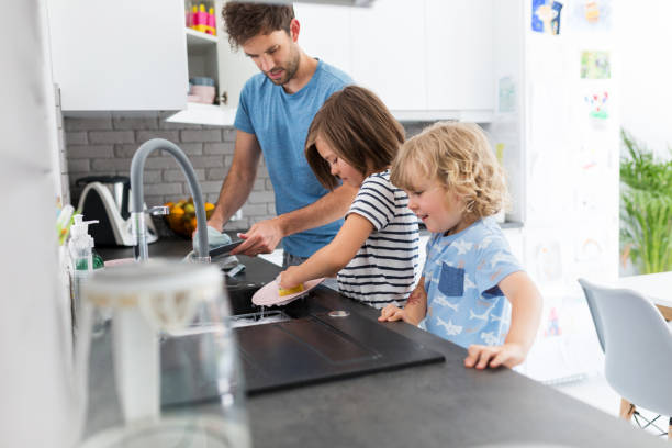 istock Father and sons washing dishes together 1152817482
