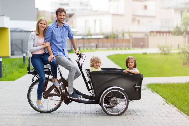 ung familj med en åktur med last cykel - parents children cargo bike bildbanksfoton och bilder