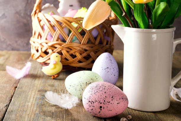 istock Yellow tulips in a vase and easter colorful eggs on a wooden table. Gift and Easter eggs. 1152818739