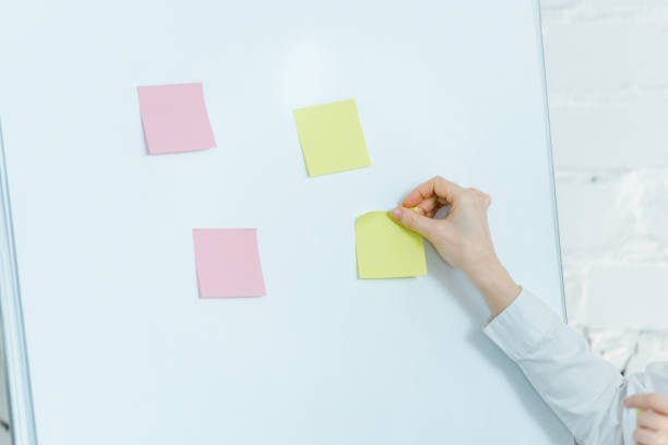 istock cropped view of business coach putting sticky notes on white board 1152819235