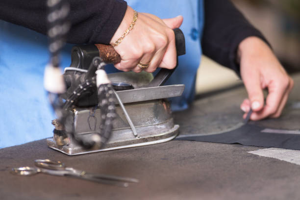 istock Semstress ironing the fabric. seamstress irons fabirc in a sewing workshop. 1152819886